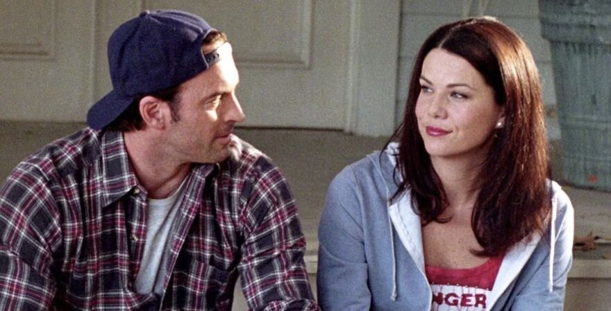 A couple sitting together, gazing at each other lovingly in Gilmore Girls.