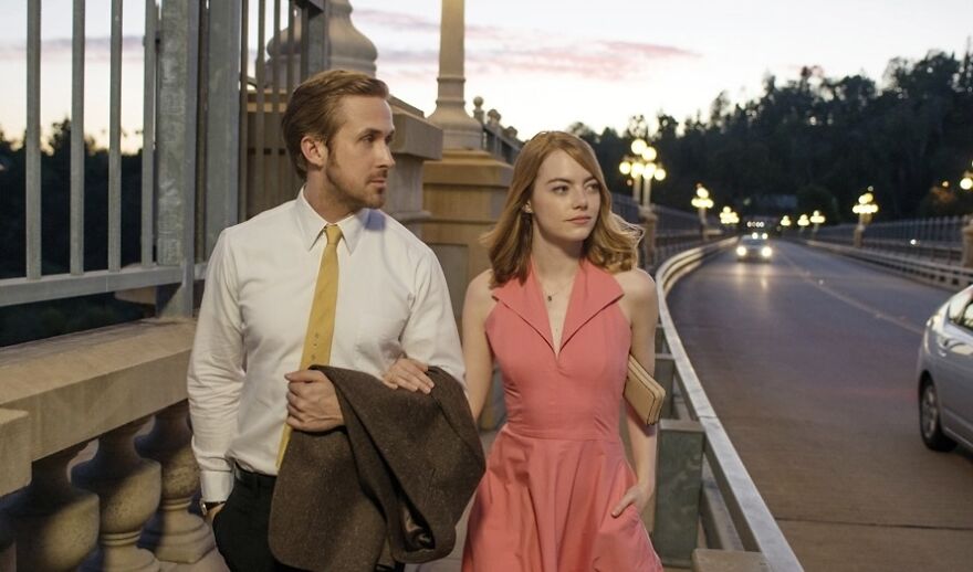 Couple walking on a bridge at sunset in the movie called La La Land.