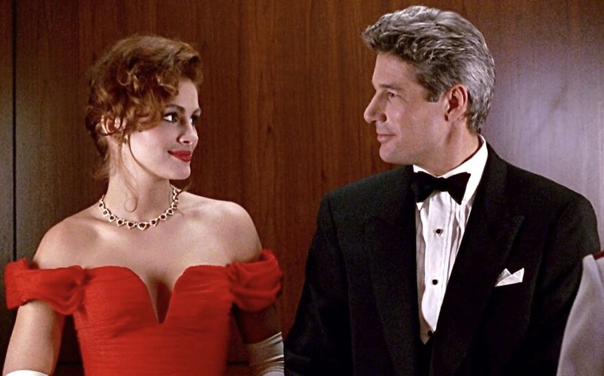 A classic movie couple gazes at each other, dressed elegantly for a formal event, highlighting their relationship dynamics in Pretty Woman.