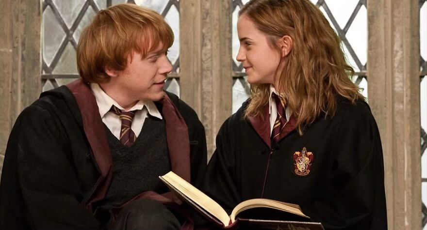 Two characters in school uniforms share a moment with an open book, highlighting a movie couple relationship in Harry Potter.