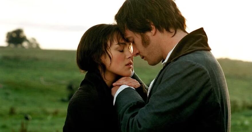 A couple in a romantic embrace in a grassy field at sunset, highlighting a classic movie couple relationship in Pride And Prejudice.