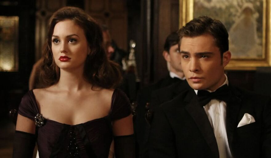 A glamorous couple in formal attire attending a movie couple relationship poll event in Gossip Girl.