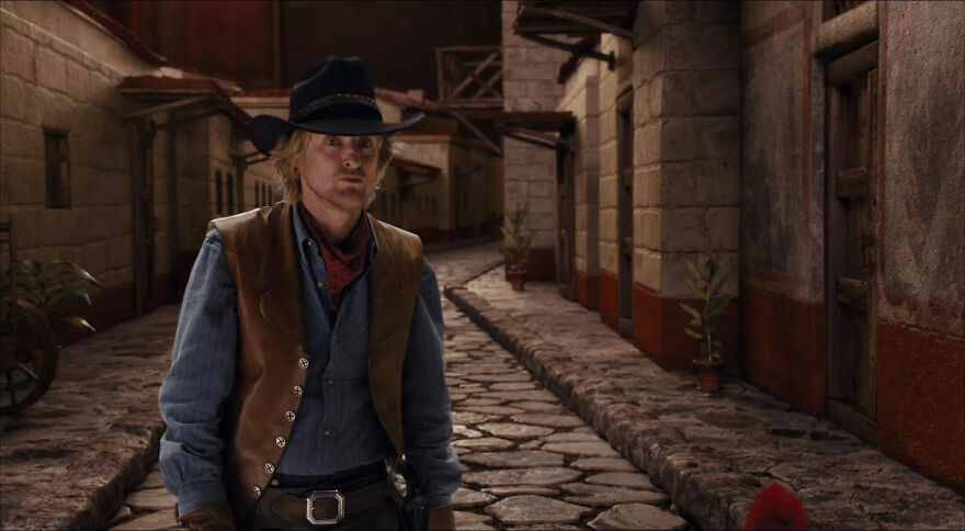 Actor Owen Wilson in cowboy attire on a cobblestone street, showcasing a typical role often portrayed.