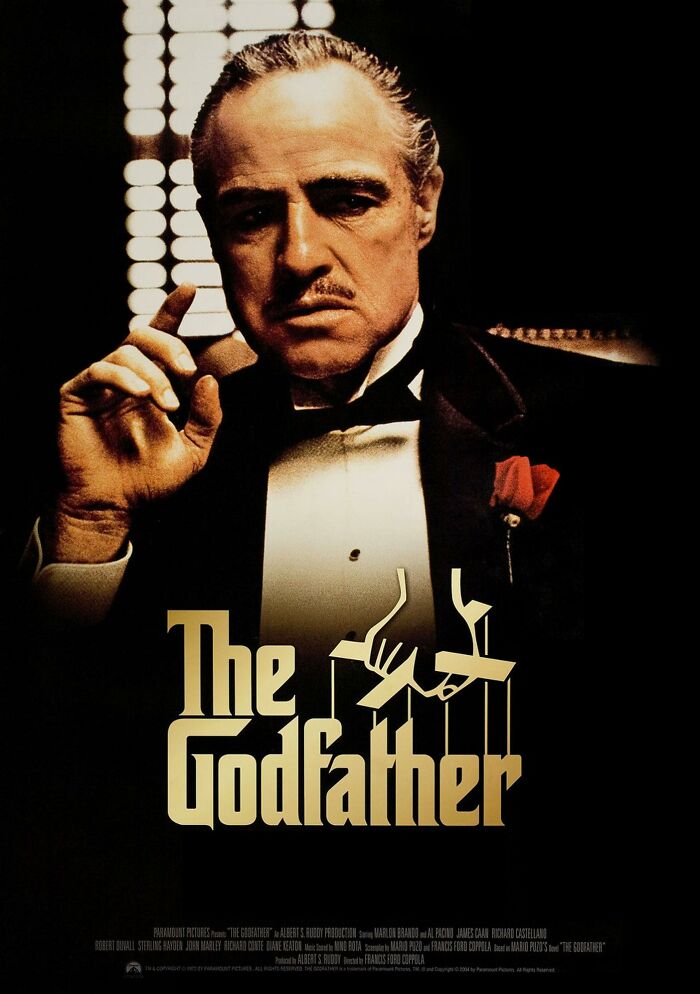 Classic movie poster for "The Godfather," depicting a serious man in a tuxedo, with prominent lighting and dark background.