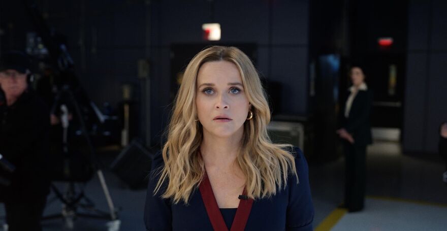 A blonde actress Reese Witherspoon with a serious expression, in a studio setting, representing actors known for consistent roles.