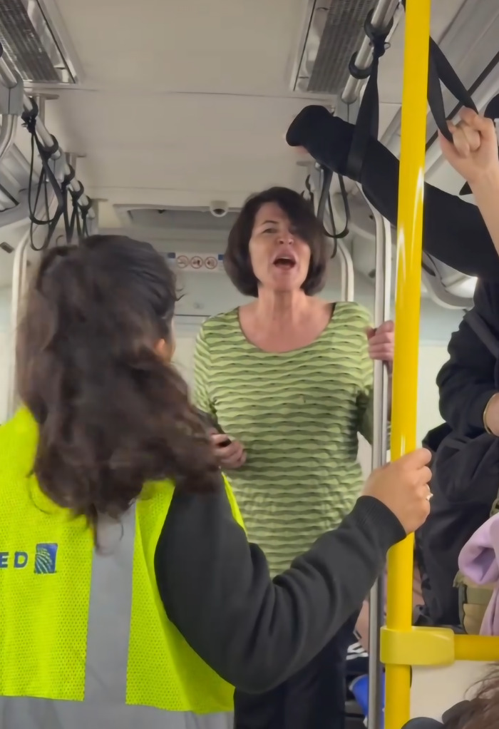 A wedding photographer and family on a crowded United bus face insults from a passenger.