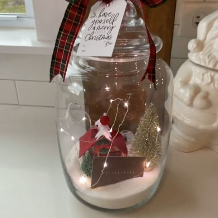 Two glass jars on a countertop, one filled with sugar and the other with flour, both containing measuring cups.