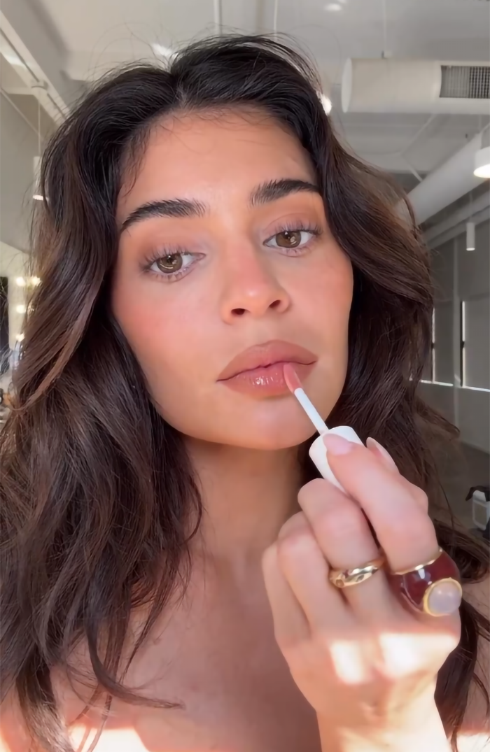 Photo of Kylie Jenner applying lip gloss.