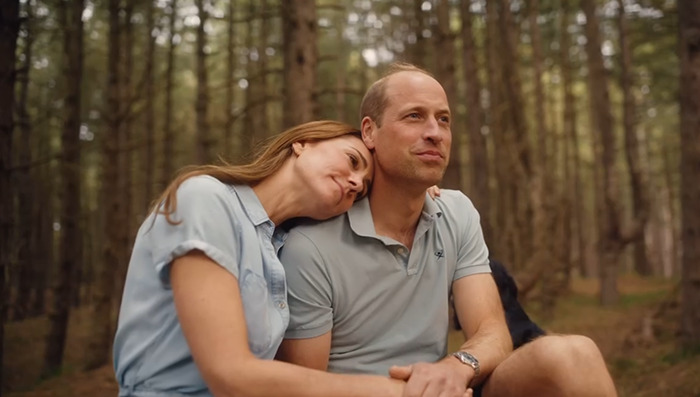 Royal couple Princess Kate and Prince William in casual wear, sitting in a forest, creating a warm vibe for their Christmas card.