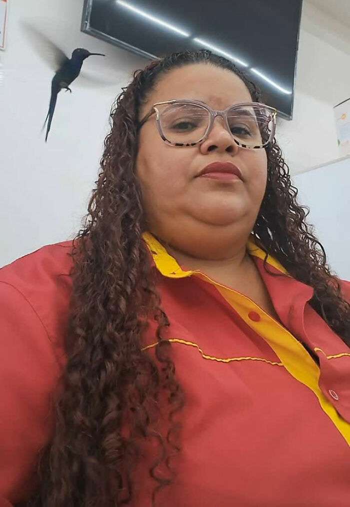 Woman in red and yellow shirt with glasses, a hummingbird hovering nearby, symbolizing a magical friendship.