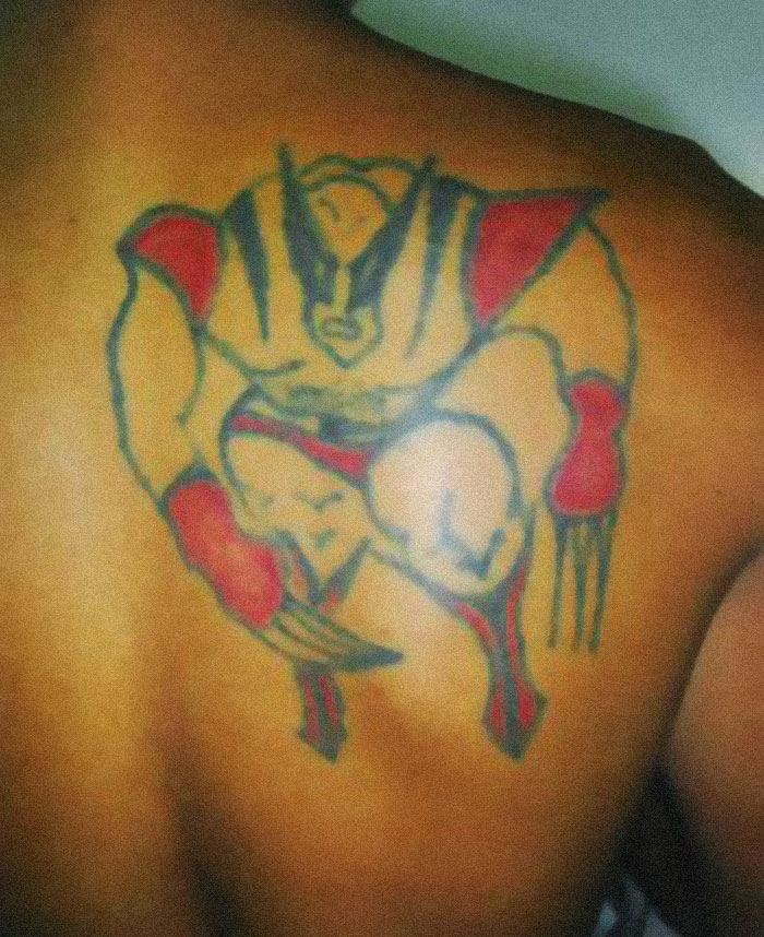 Poorly drawn superhero tattoo on a person's back, exemplifying funny worst tattoo fails with odd proportions.