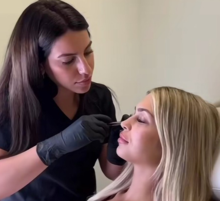 Beautician performing a procedure on woman; highlights dangerous beauty trend risking reptile-like appearance.