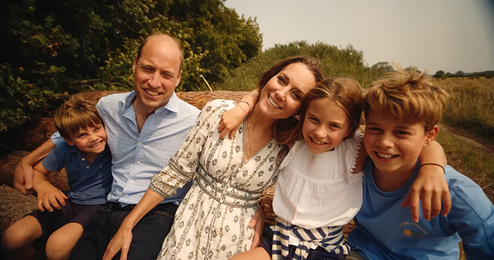 Princess Kate and Prince William with their children, smiling outdoors for Christmas card, after previous Photoshop controversy.