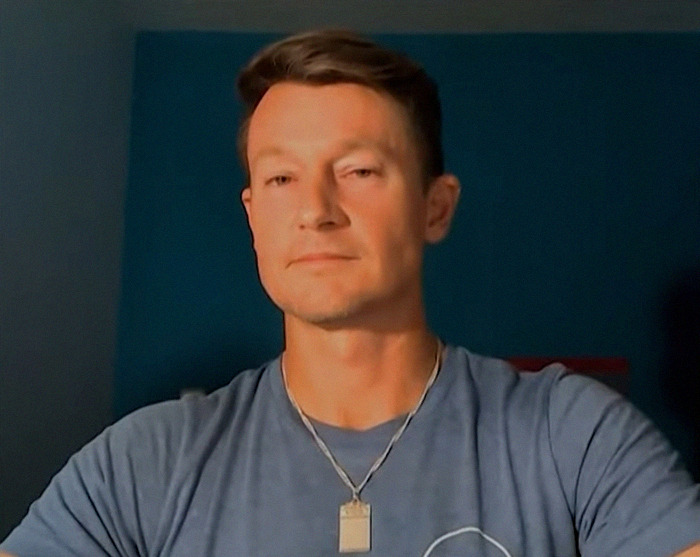 Luigi Mangione's former roommate R.J. Martin in a blue t-shirt and necklace.