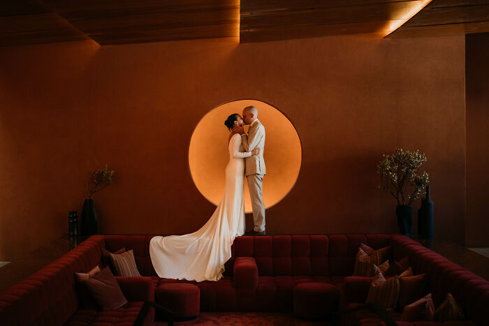 Elegant wedding couple embracing in a modern setting with ambient lighting, showcasing one of the top photos of 2024.