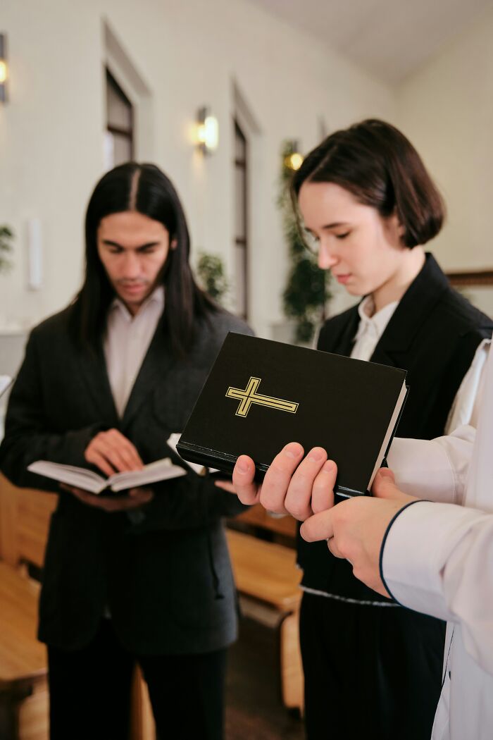 People reading books in a church setting, symbolizing private judgments in social contexts.