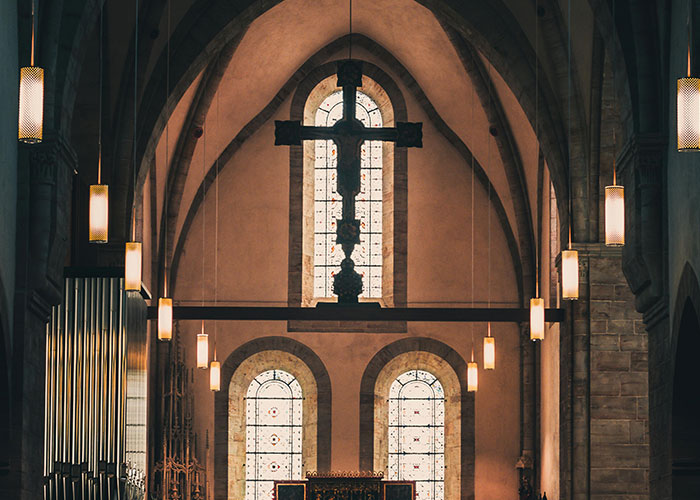 Gothic church interior with large cross and stained glass windows, related to wedding date change context.