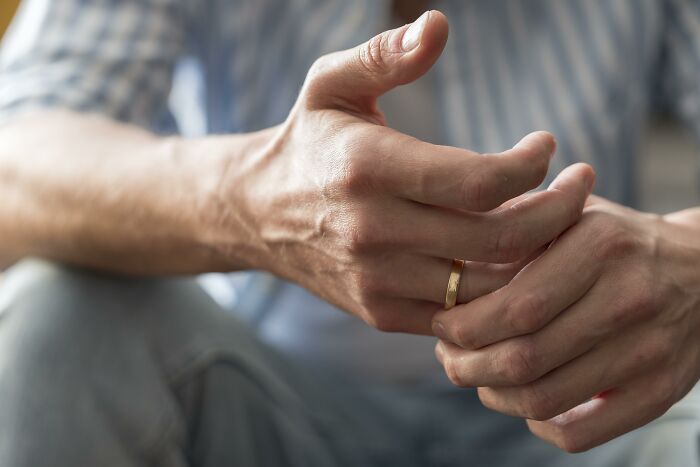 Hands fidgeting with a ring, illustrating bad-good-habit concept in a thoughtful setting.