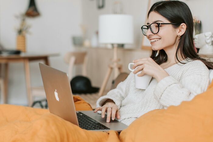 Woman enjoying a coffee while working on a laptop, illustrating a good habit.