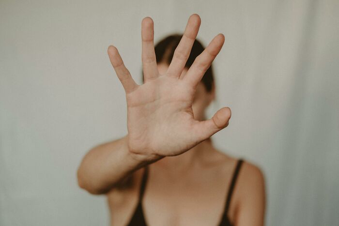 A person holding up their hand, symbolizing stopping a bad habit.