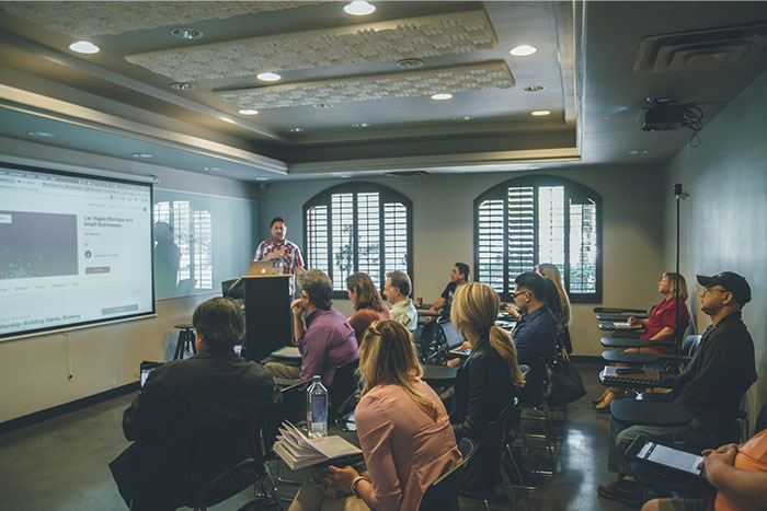 A presenter in a classroom giving a school presentation to an audience.