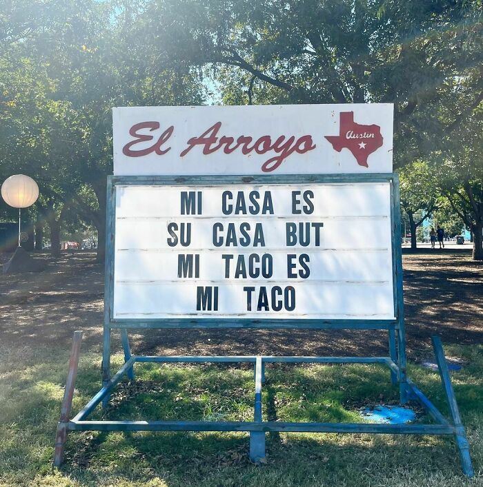 El Arroyo sign with text "Mi casa es su casa but mi taco es mi taco" in a sunny outdoor setting.