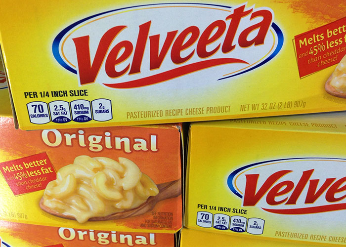 Velveeta cheese boxes stacked in someone else's home, showcasing the original variety with nutrition information.