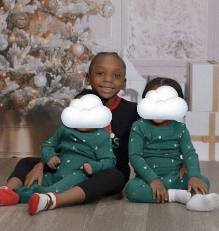 Children in Christmas setting, one wearing different pyjamas, capturing family moment amid pyjama choice discussion.