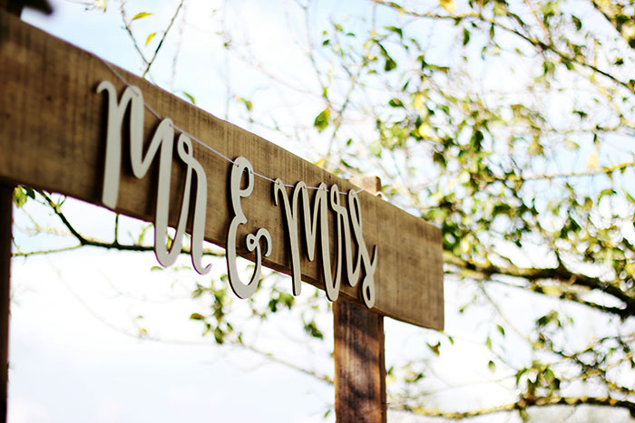 "Mr & Mrs wedding sign outdoors, bright day with leaves in background, relating to child-free wedding topic.