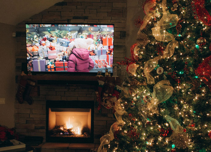 "Christmas tree and fireplace with a TV showing a scene from a Rocky movie, creating a festive brotherly atmosphere.