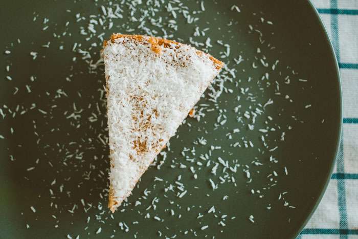 A slice of coconut-covered cake on a plate for a friend's birthday party.