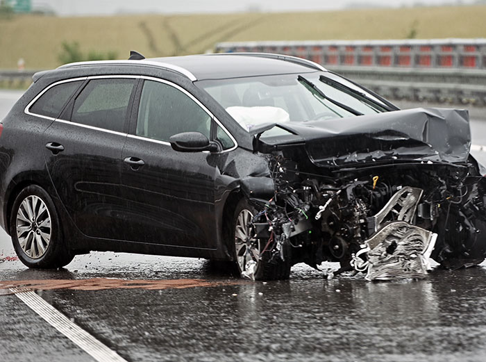 Crashed car on rainy road, insurance claim denial issues with UnitedHealthcare.