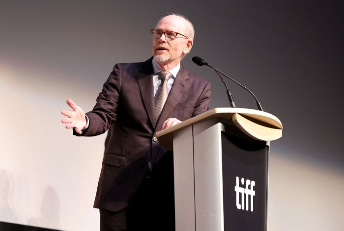 A speaker at a podium during a TIFF event, highlighting stars and hidden gems from Only Murders in the Building Season 4.