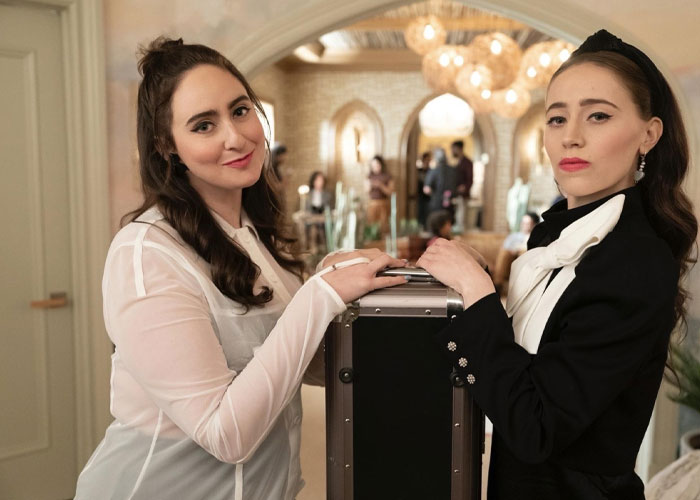 Two actresses from Only Murders in the Building pose together inside a stylish room.