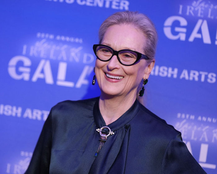 A-list star wearing glasses and elegant attire at a gala event.