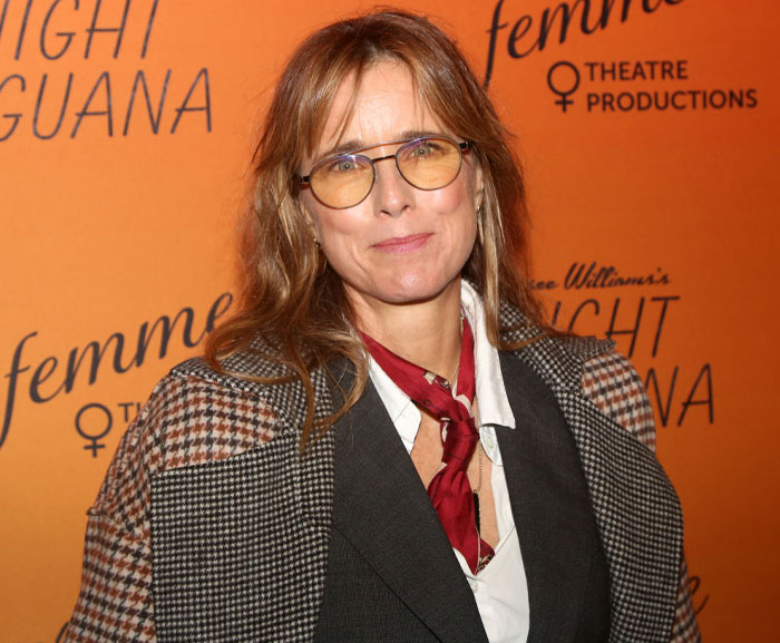 A cast member from Only Murders in the Building Season 4, wearing glasses and a checkered jacket at a theatre production event.