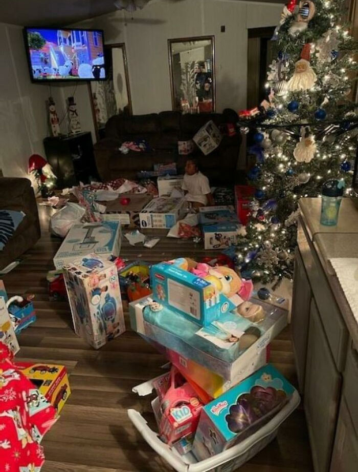 Christmas tree with scattered presents and toys, creating a cluttered scene, showing holiday chaos.