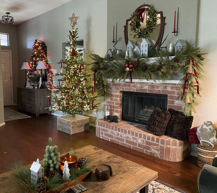 Christmas decorating ideas with a lit tree, adorned fireplace, and festive mantel in a cozy living room.