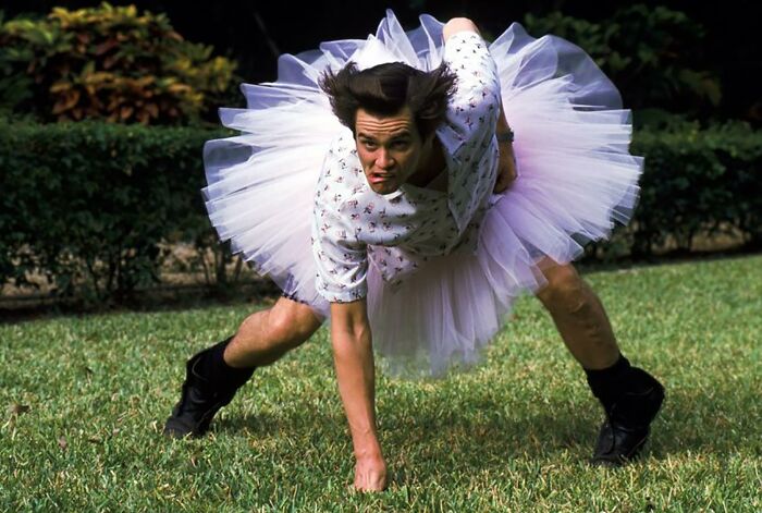 Man in a tutu striking a humorous pose outdoors, showcasing quirky thoughts and expressions.