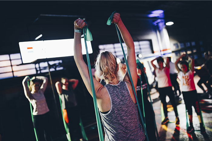 Group exercise class using resistance bands, showcasing crazy body life hacks for fitness enthusiasts.