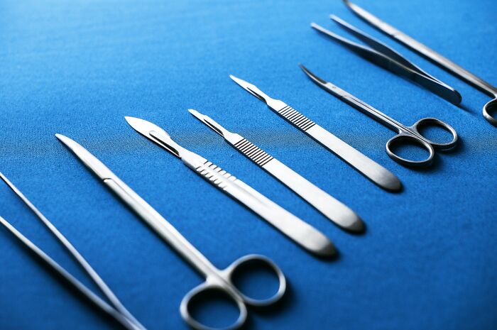 Surgical instruments on a blue cloth, reflecting on current medical practices and their future perception as barbaric.