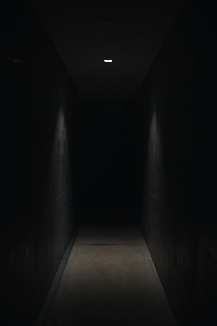 Dark, dimly lit corridor symbolizing secrets hidden from loved ones.