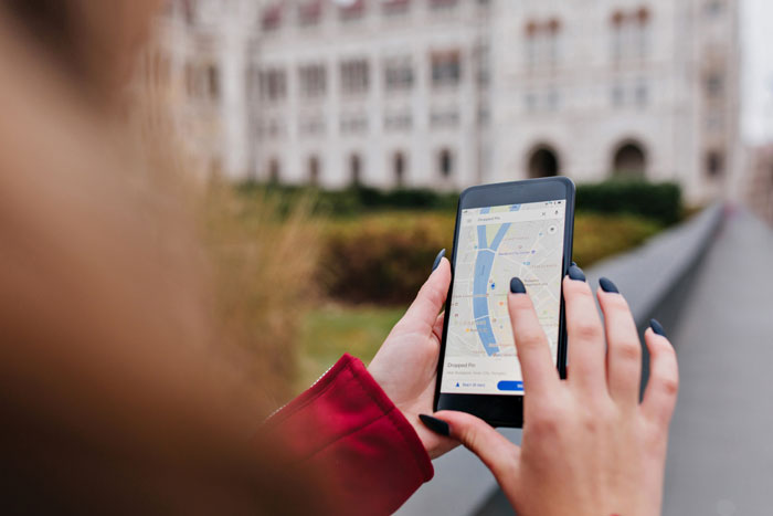 Person using a smartphone with a map app open, illustrating daughter using phone as a mom tracker.