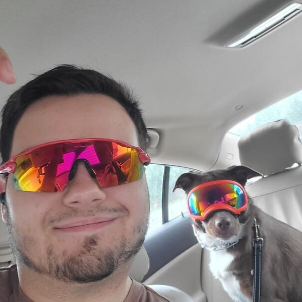 Man and dog wearing goggles in a car, both with reflective eyewear, showcasing fun eyewear for dogs.