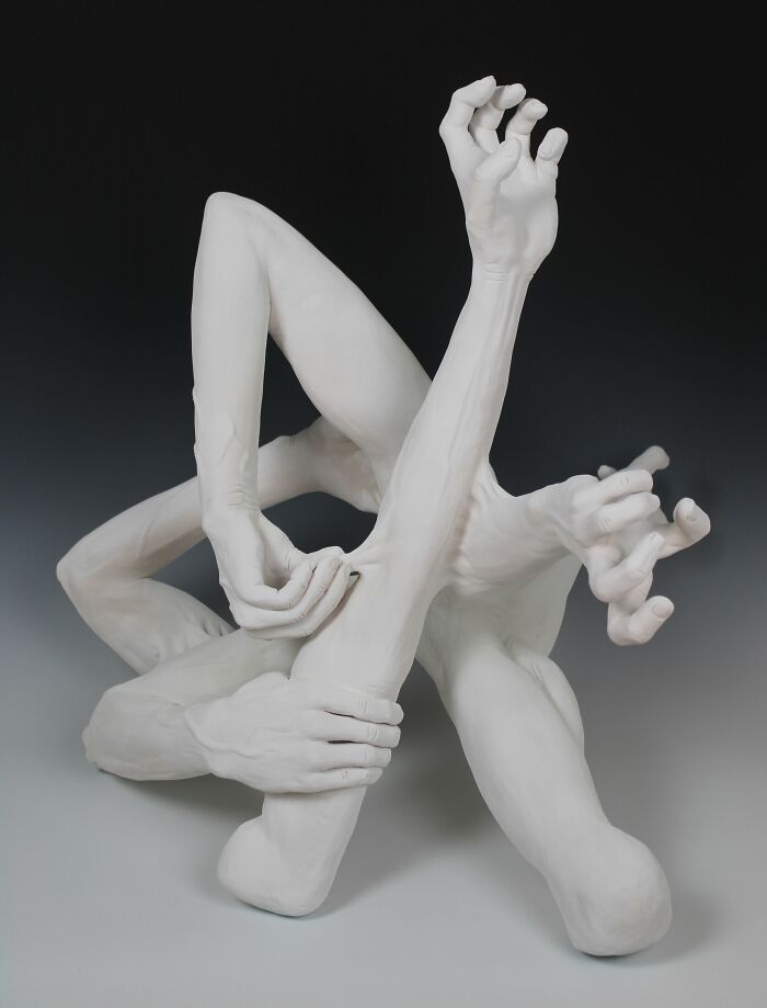 Surreal ceramic art depicting intertwined hands and limbs, showcasing emotional expression.