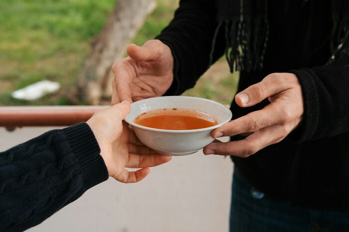 Two people exchanging a bowl of soup, illustrating job secrets and insights in a casual setting.