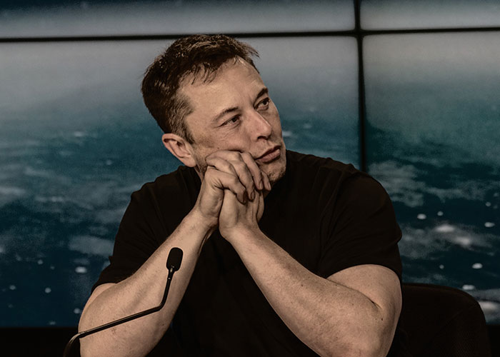 A CEO at a conference table, pondering with hands clasped, exemplifying management challenges.