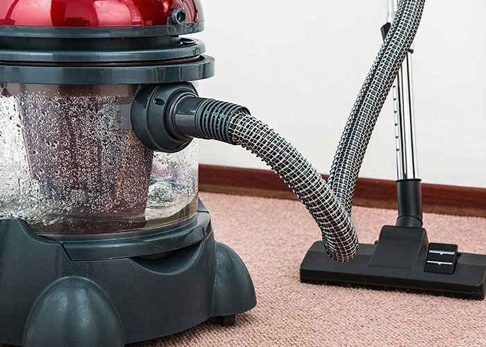 Vacuum cleaner on carpet, illustrating management failures in product design by CEOs.