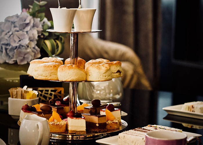 Afternoon tea set with scones and pastries, highlighting indulgence amidst fat-shaming discussions.