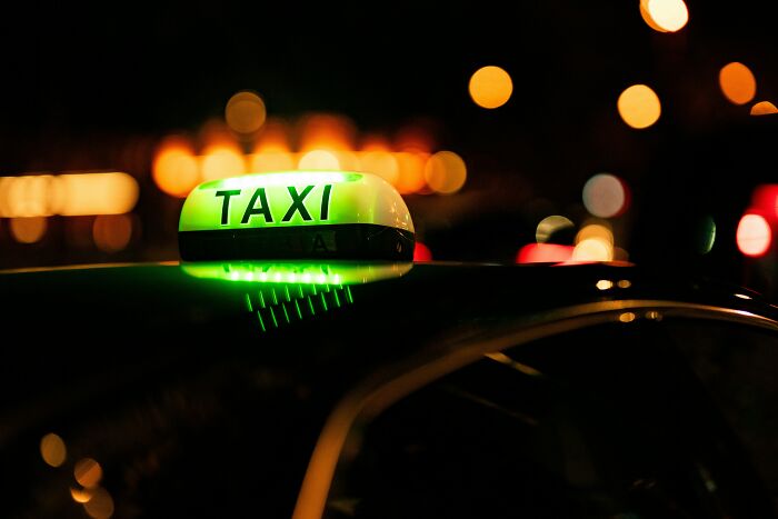 Taxi sign glowing at night, capturing an astonishing coincidence in urban life.